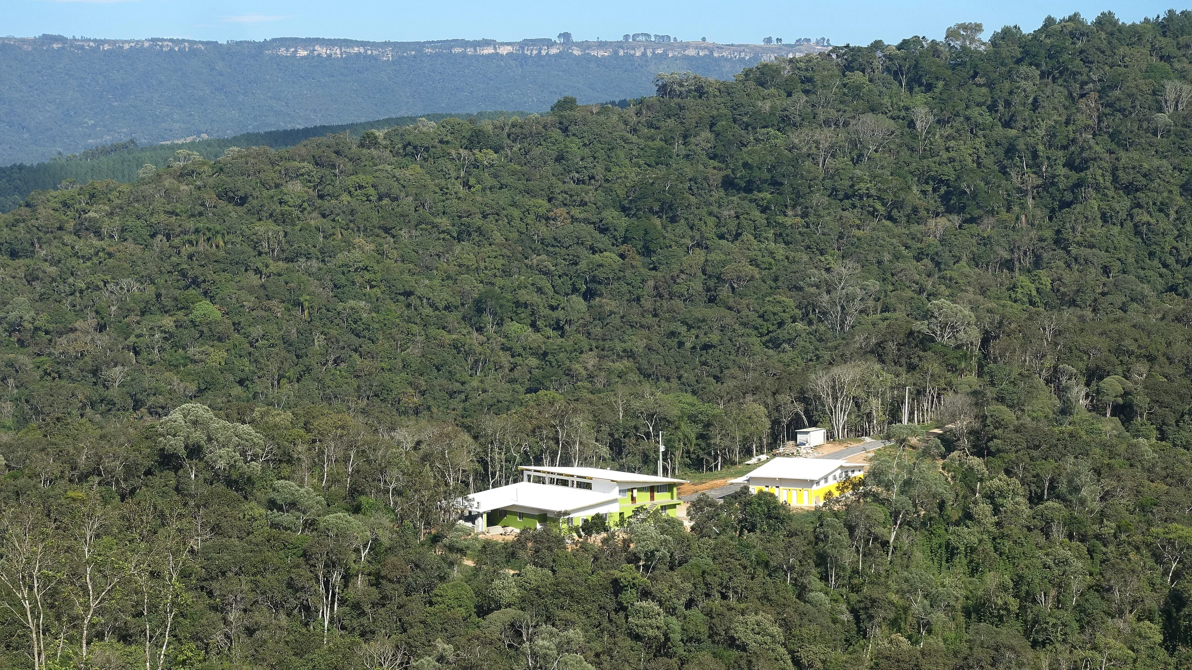 Vista aérea do vale com a sede da reserva e escarpa ao fundo