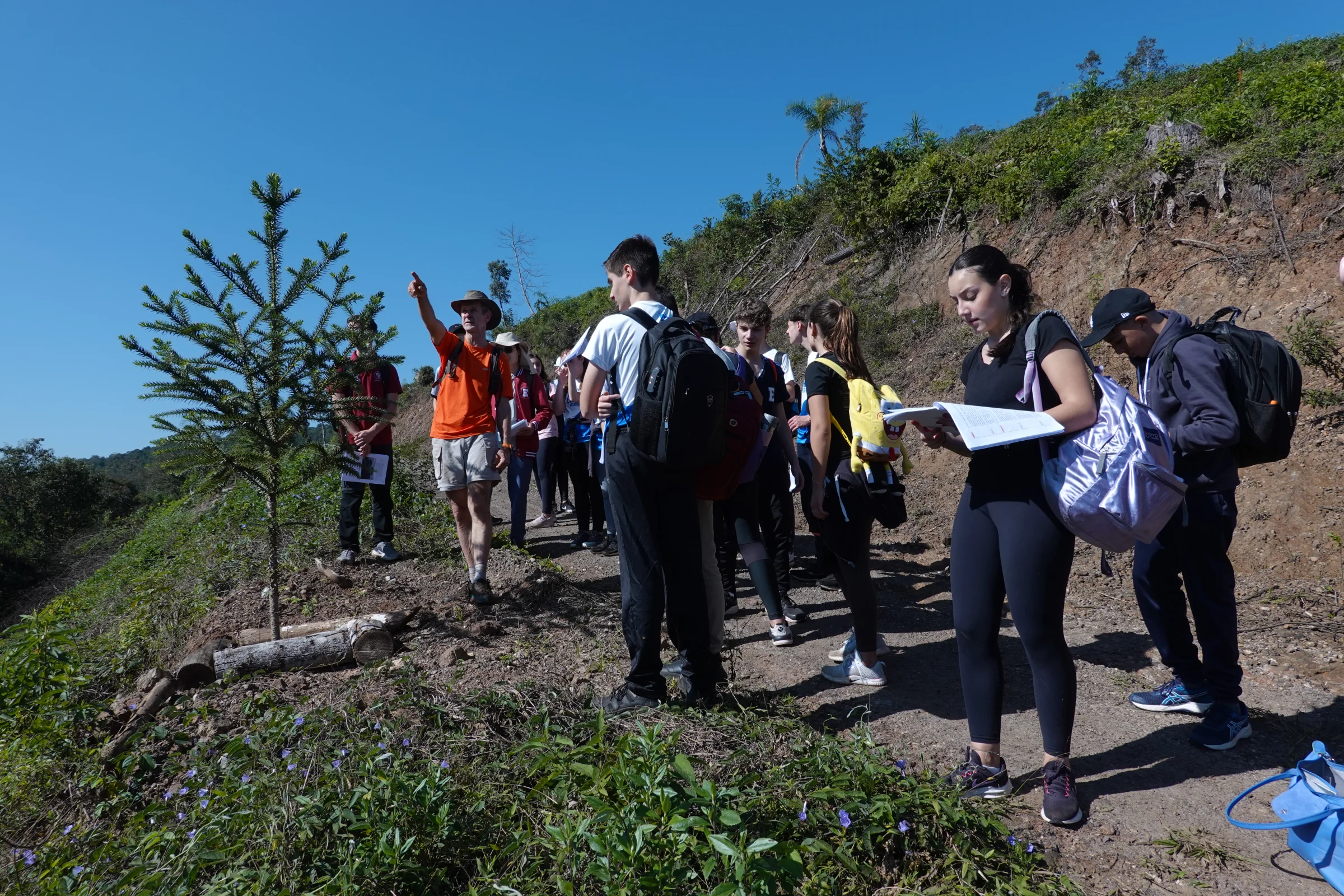 Educador com alunos atentos em campo