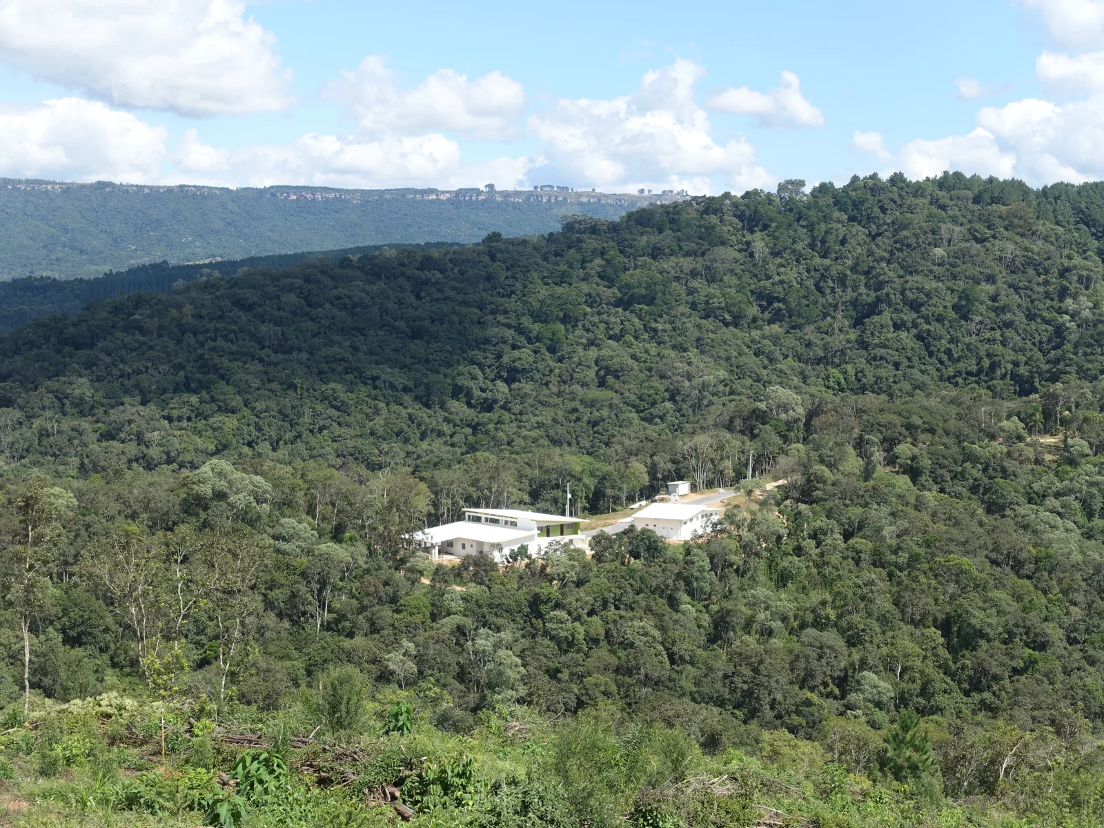 Sede da reserva no meio da mata atlântica com escarpa ao fundo